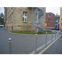 Außenansicht eines Gebäudes mit einer Wendeltreppe und Straßenbegrenzungspfosten.