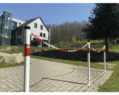 Absperrpfosten mit rot-weißer Kette auf einem Gehweg