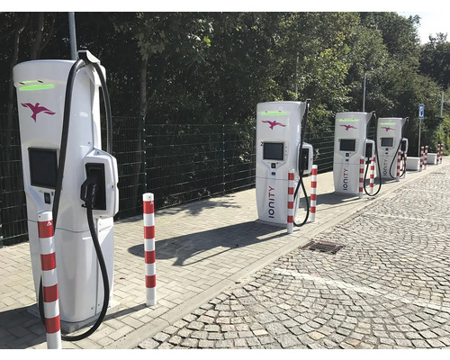 Mehrere Ladestationen für Elektroautos entlang einer Straße.