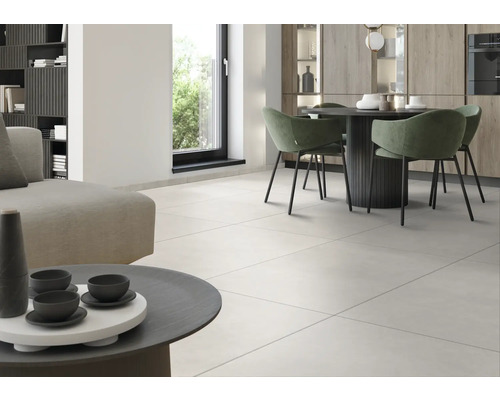 Heller Wohnraum mit Fliesenboden, Esstisch und Sitzgelegenheiten.