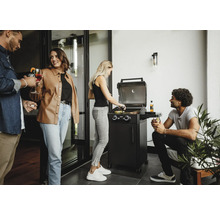 Personen grillen mit einem Gasgrill auf einer Terrasse