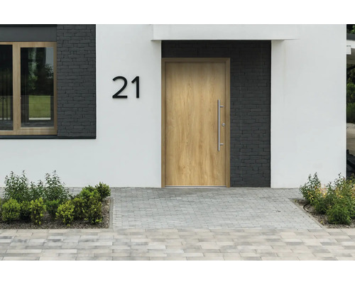 Hausfassade mit Haustür, Hausnummer 21 und gepflastertem Gehweg