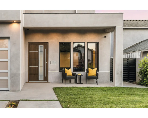 Modernes Haus mit Haustür, Fenstern und Gartenbereich.