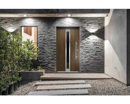 Haustür mit Fenster in Steinmauer und gepflastertem Eingangsbereich