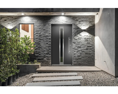 Moderne Haustür mit Seitenelement und Griffleiste vor einer Steinwand