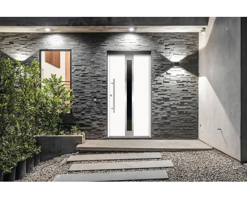 Eingangsbereich eines Hauses mit Haustür, Steinmauer und Bepflanzung