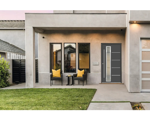 Moderne Hausfassade mit Eingangstür, Fenstern und Sitzbereich auf der Terrasse