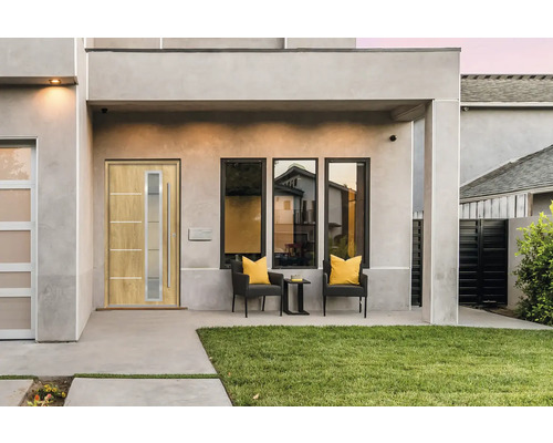 Hausfassade mit Haustür, Fenstern und Sitzgelegenheiten im Außenbereich