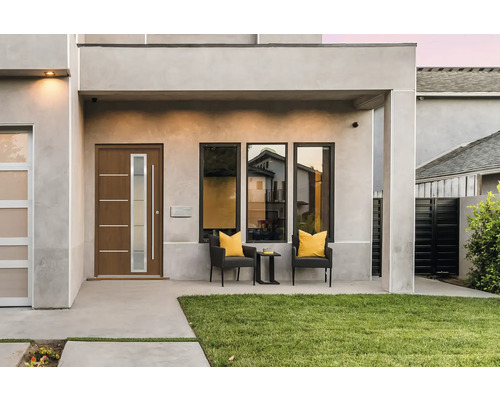 Hausfassade mit Haustür, Fenstern und Sitzbereich im Außenbereich