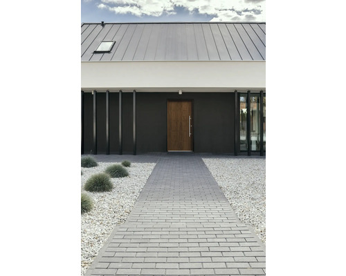 Modernes Haus mit Pflasterweg, Kiesbeet und Holztür