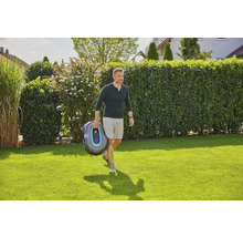 Mann trägt Gardena Mähroboter im Garten