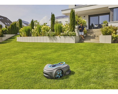 Rasenmähroboter auf einem Rasen vor einem Wohnhaus