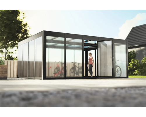 Gewächshaus SunGarden Select 5.4 Polycarbonat 10 mm 548 x 443 cm anthrazit Fahrradgarage mit Fahrrädern und einer Frau, die hineingeht