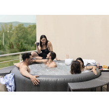 Aufblasbarer Whirlpool mit mehreren Personen im Freien auf einer Terrasse.