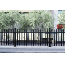 Schwarzer Metallzaun vor einem Gebäude mit Bäumen