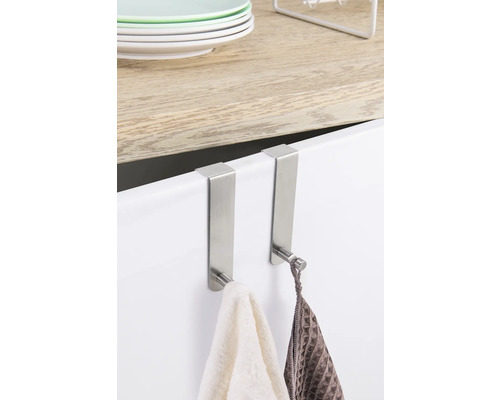 Zwei Türhaken aus Metall mit Handtüchern hängen an einer Schranktür