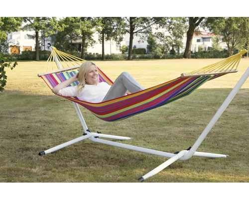 Frau entspannt in einer gestreiften Hängematte mit Gestell im Garten.