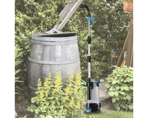 Regentonnenpumpe im Einsatz im Garten neben einer Regentonne