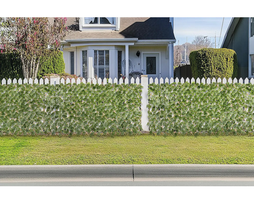 Dekorativer Sichtschutz mit Pflanzenmotiven vor einem Haus