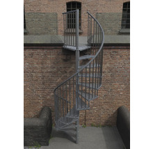 Außentreppe aus Metall mit spiralförmigem Treppenlauf vor einer Backsteinmauer