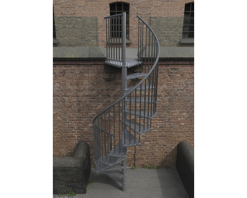 Außentreppe aus Metall mit spiralförmigem Treppenlauf vor einer Backsteinmauer