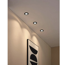 Decke mit drei runden Einbauspots und einem gerahmten Bild an der Wand