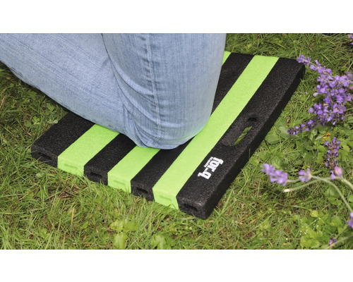 Person kniet auf einer Gartenkniematte mit Streifenmuster auf Rasen