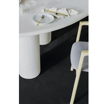 Detailaufnahme eines Zimmers mit einem weißen Tisch, einem Stuhl und einem dunklen Teppich