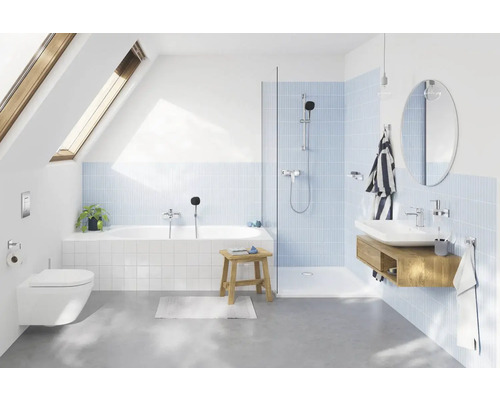 Modernes Badezimmer mit Badewanne, Dusche, Waschbecken und Toilette unter einem Dachfenster.