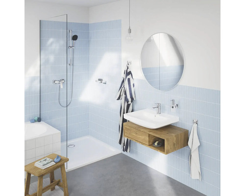 Badezimmer mit Dusche, Waschbecken, Spiegel und hellblauen Fliesen