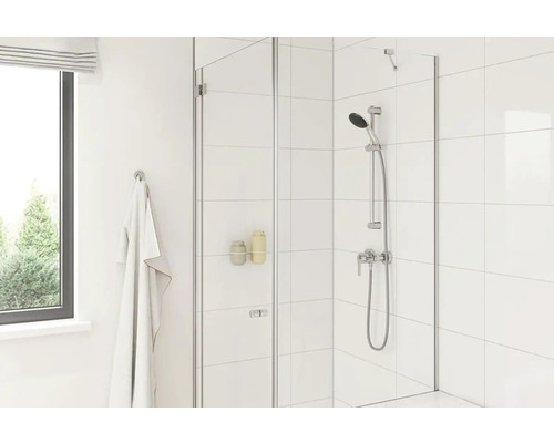 Helles Badezimmer mit Duschabtrennung aus Glas, Handbrause und weißer Fliesenwand.