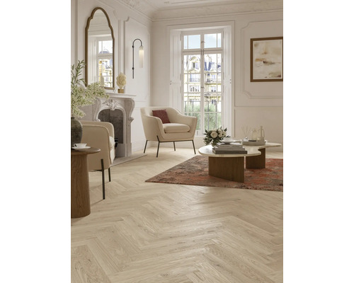 Heller Wohnraum mit Fischgrätparkett, Sesseln und Kamin