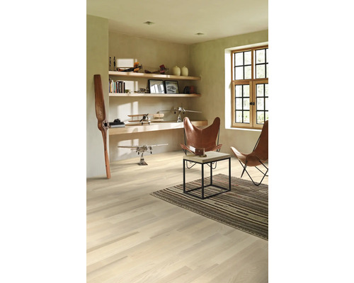 Heller Raum mit Holzfußboden, Regalen, Dekoration und zwei Ledersesseln