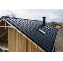 Ansicht eines Hauses mit Metalldach, Dachfenstern und Schornstein.