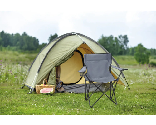 Camping Szene mit Zelt, Picknickkorb und Campingstuhl auf einer Wiese