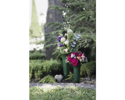 Zwei Grabvasen mit Blumenschmuck und ein Herz aus Stein auf einem Grab