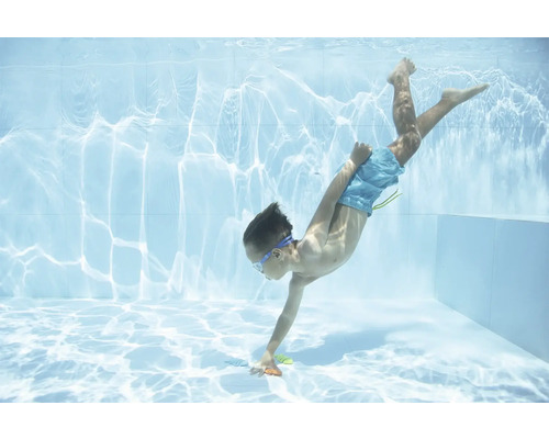 Kind taucht im Schwimmbad nach Spielzeug