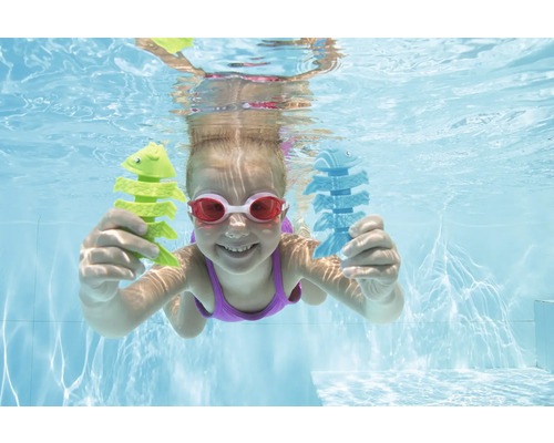 Mädchen taucht mit Fischspielzeug im Schwimmbad