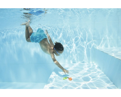 Junge taucht nach Spielzeug im Pool