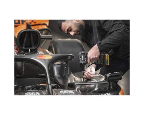 Ein Mann verwendet einen Akku-Bohrschrauber von DeWalt an einem Rennwagen.