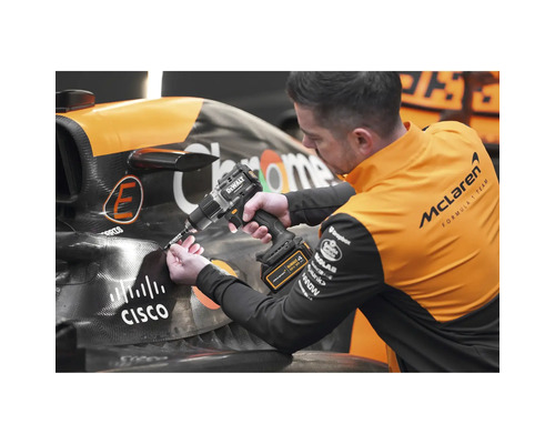 Ein Mann arbeitet mit einem Akkubohrer von Dewalt an einem Rennwagen.