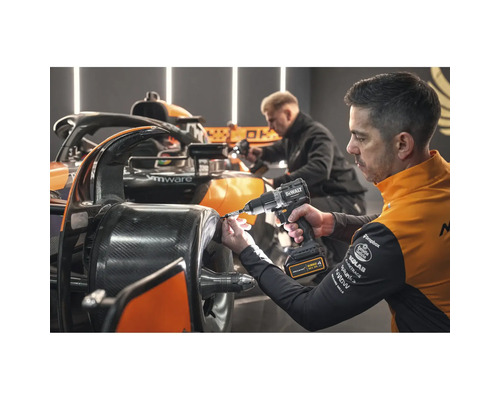 Ein Mann benutzt einen Akku-Bohrschrauber von DeWalt an einem Rennwagen.