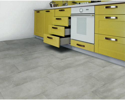 Heller Küchenraum mit Bodenfliesen in Betonoptik und gelber Küchenzeile.