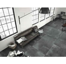 Wohnzimmer mit grauen Bodenfliesen, Sofa, Fenstern und Schreibtisch