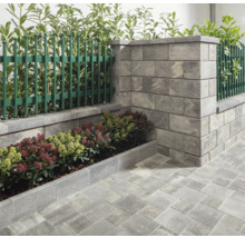 Gartenmauer mit Zaunelementen, Beetbegrenzung und Pflastersteinen für eine strukturierte Gartengestaltung