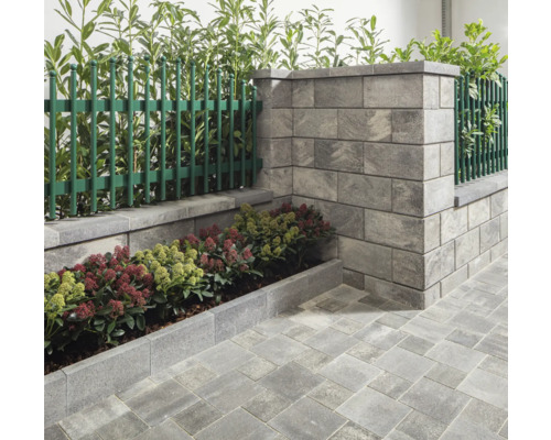Gartenmauer mit Zaunelementen, Beetbegrenzung und Pflastersteinen für eine strukturierte Gartengestaltung