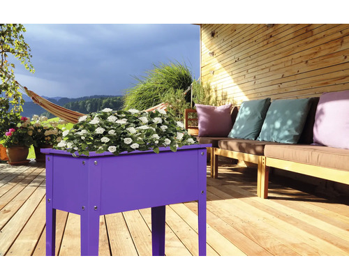 Blumenkasten aus Holz auf einer Terrasse mit Sitzgelegenheiten und Hängematte