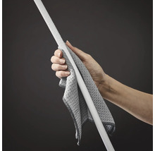 Eine Hand hält einen weißen Stab mit einem grauen Reinigungstuch.
