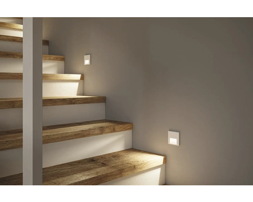 Treppe mit Holzstufen und eingelassenen Wandleuchten zur Beleuchtung