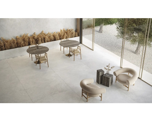 Heller Raum mit Tischen, Stühlen und Steinfliesen